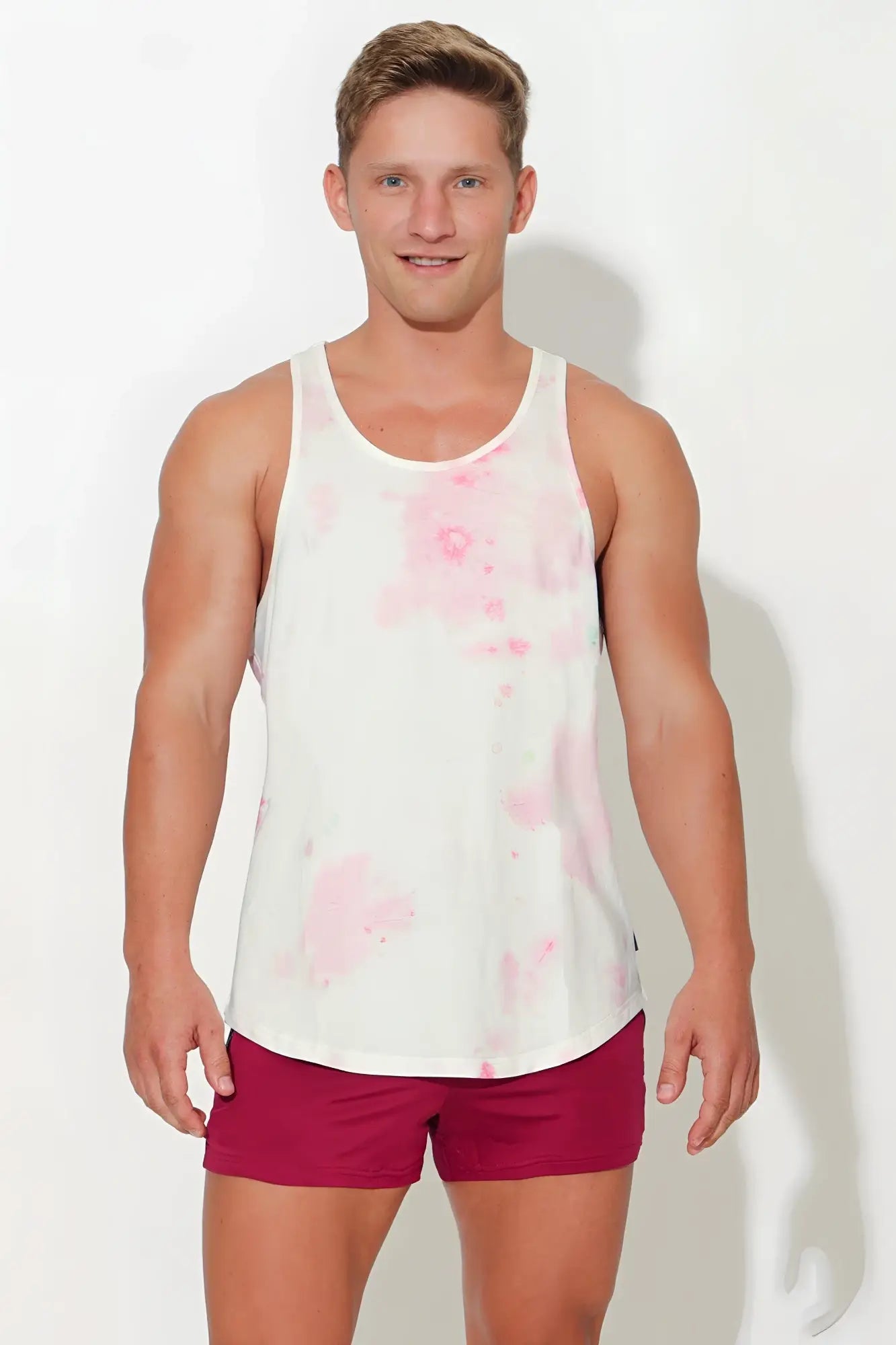 White tank top with pink tie dye watercolor splatter design featuring scoop bottom style in soft fabric