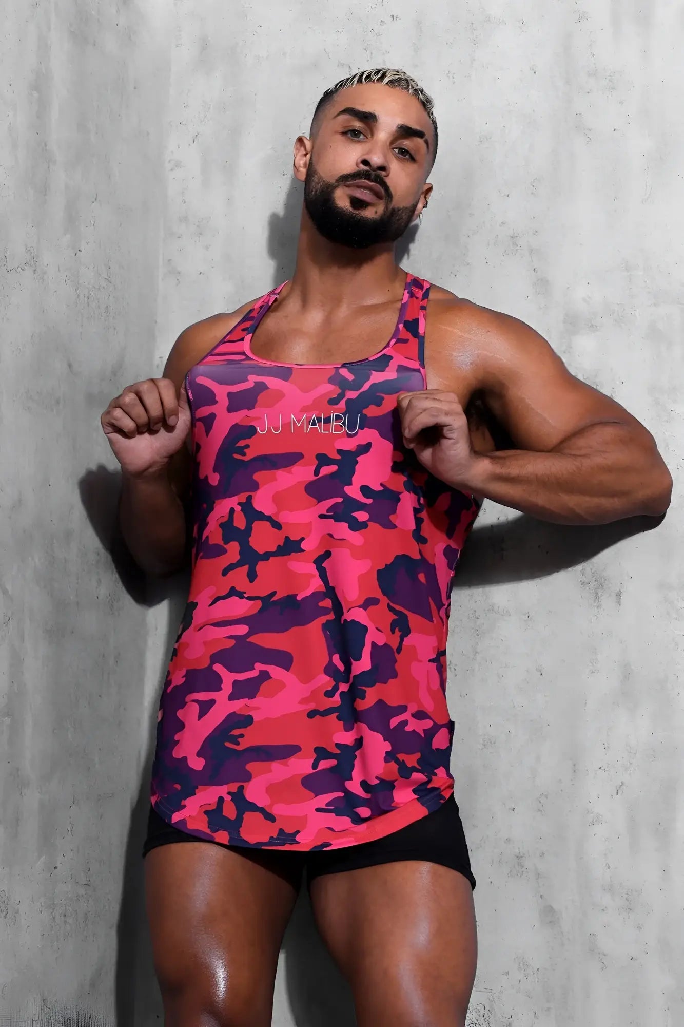 A vibrant pink and purple camouflage racerback tank top with scoop bottom in soft breathable fabric