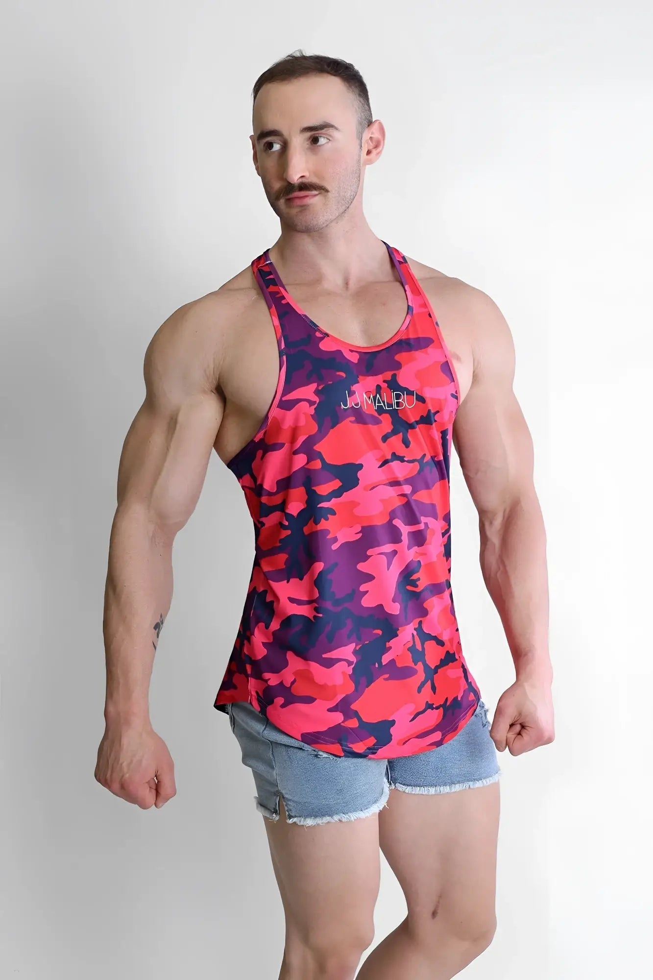 A vibrant pink and purple camouflage racerback tank top with jomau embroidery called feel-me scoop bottom tank purple camo