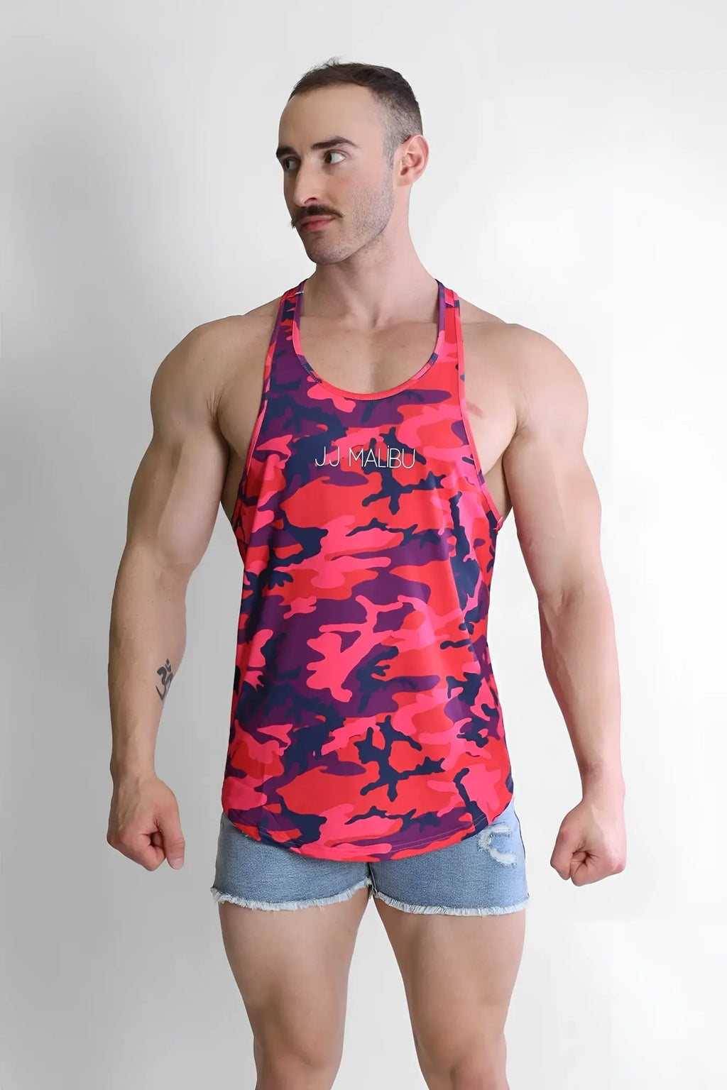 A vibrant pink and navy camouflage patterned tank top with a subtle jd malbu logo across the chest