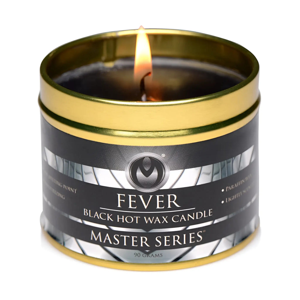 A lit black hot wax candle in a gold-toned metal tin labeled fever from the master series for relaxation