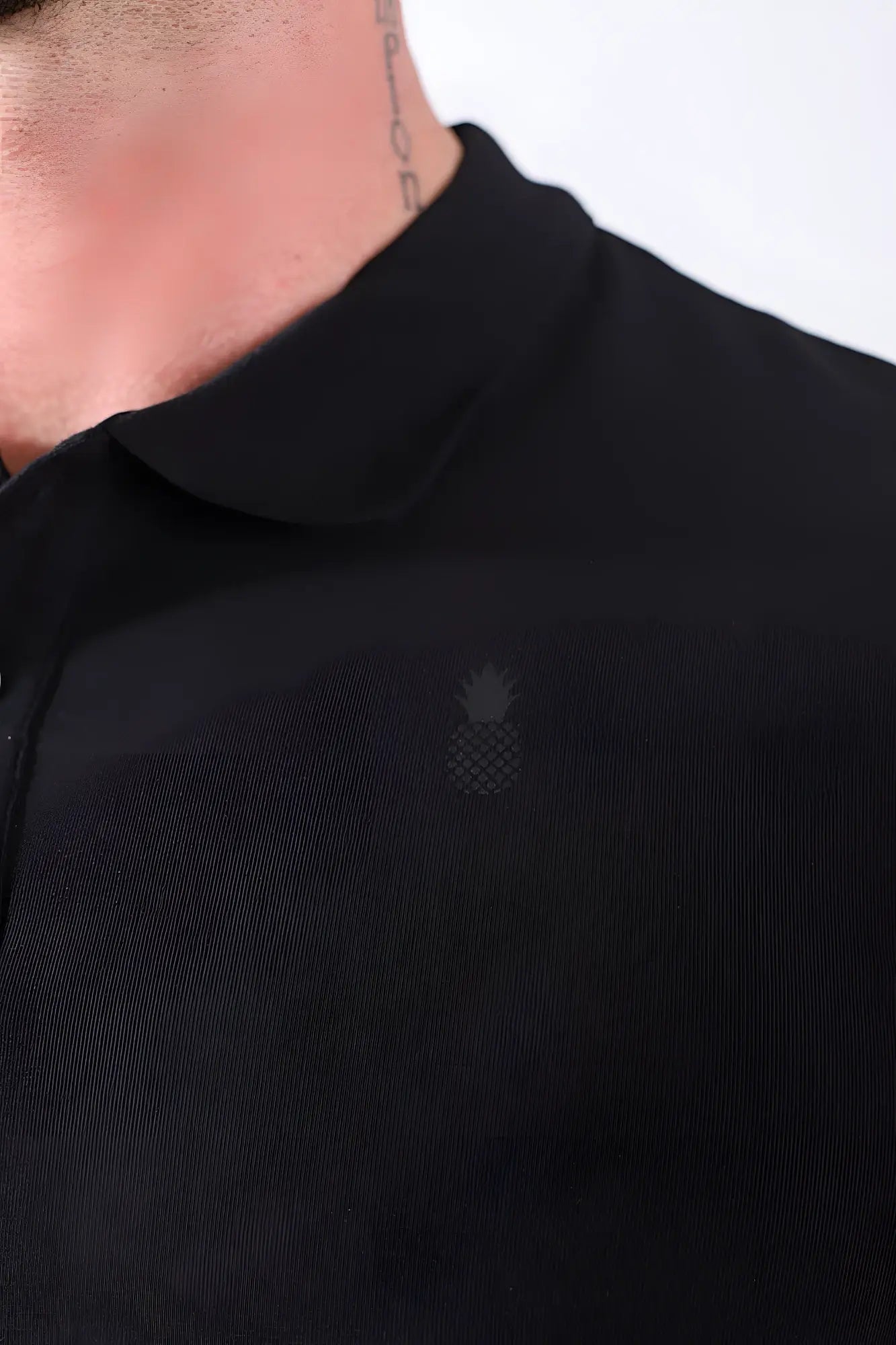 Fitted polo crop top in black featuring a subtle embroidered pineapple logo on the chest in soft cotton fabric