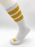 White athletic tube sock by fk sport with three mustard-yellow stripes and a small yellow logo on the toe