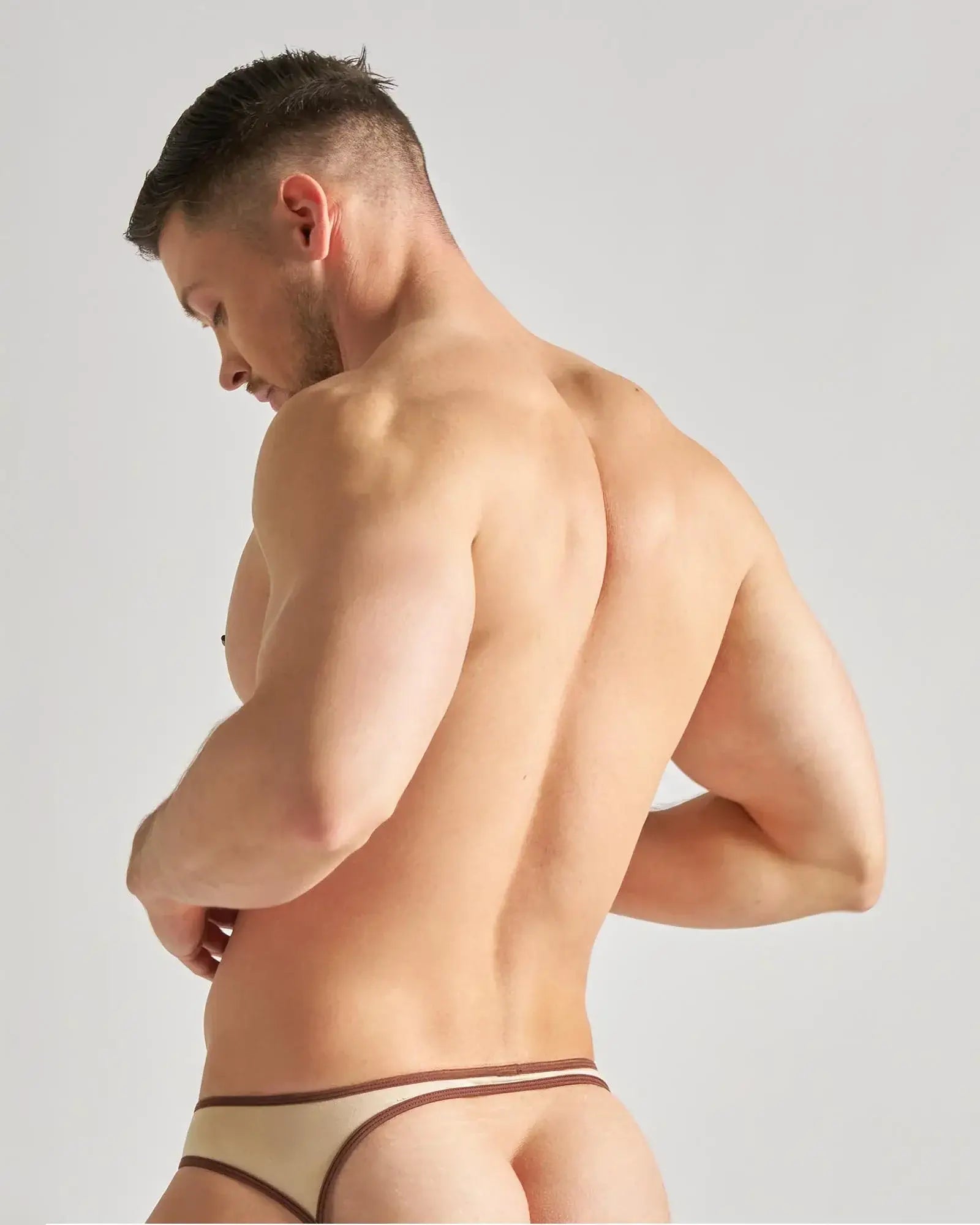 Beige flaunt jockstrap thong with brown trim designed for comfortable and stylish men’s underwear wear