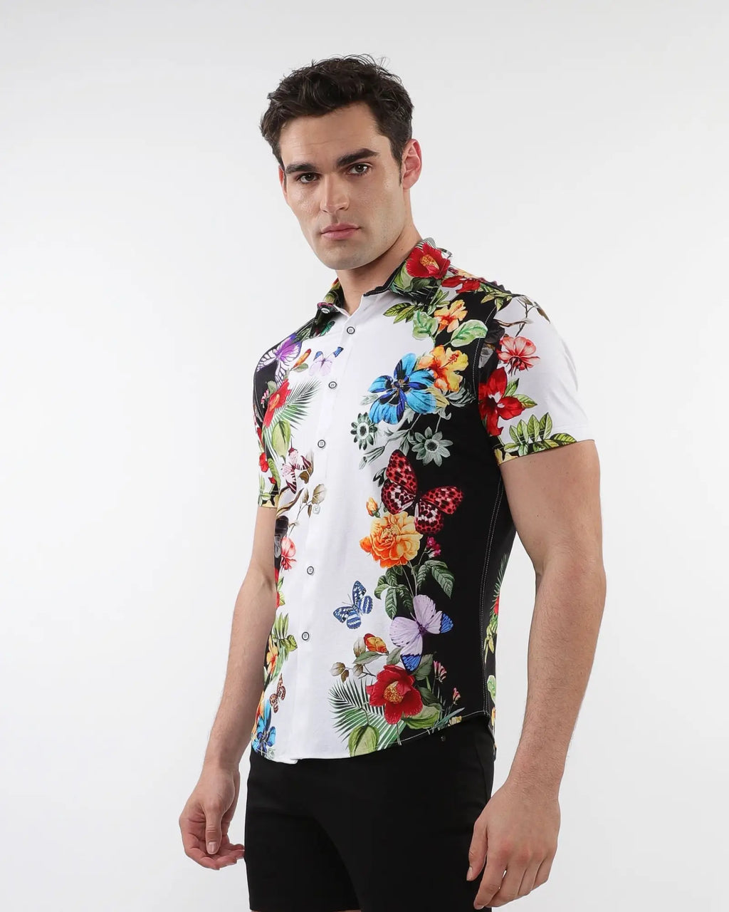 A vibrant short-sleeved floral border print stretch knit shirt with bold tropical flowers and butterflies on white
