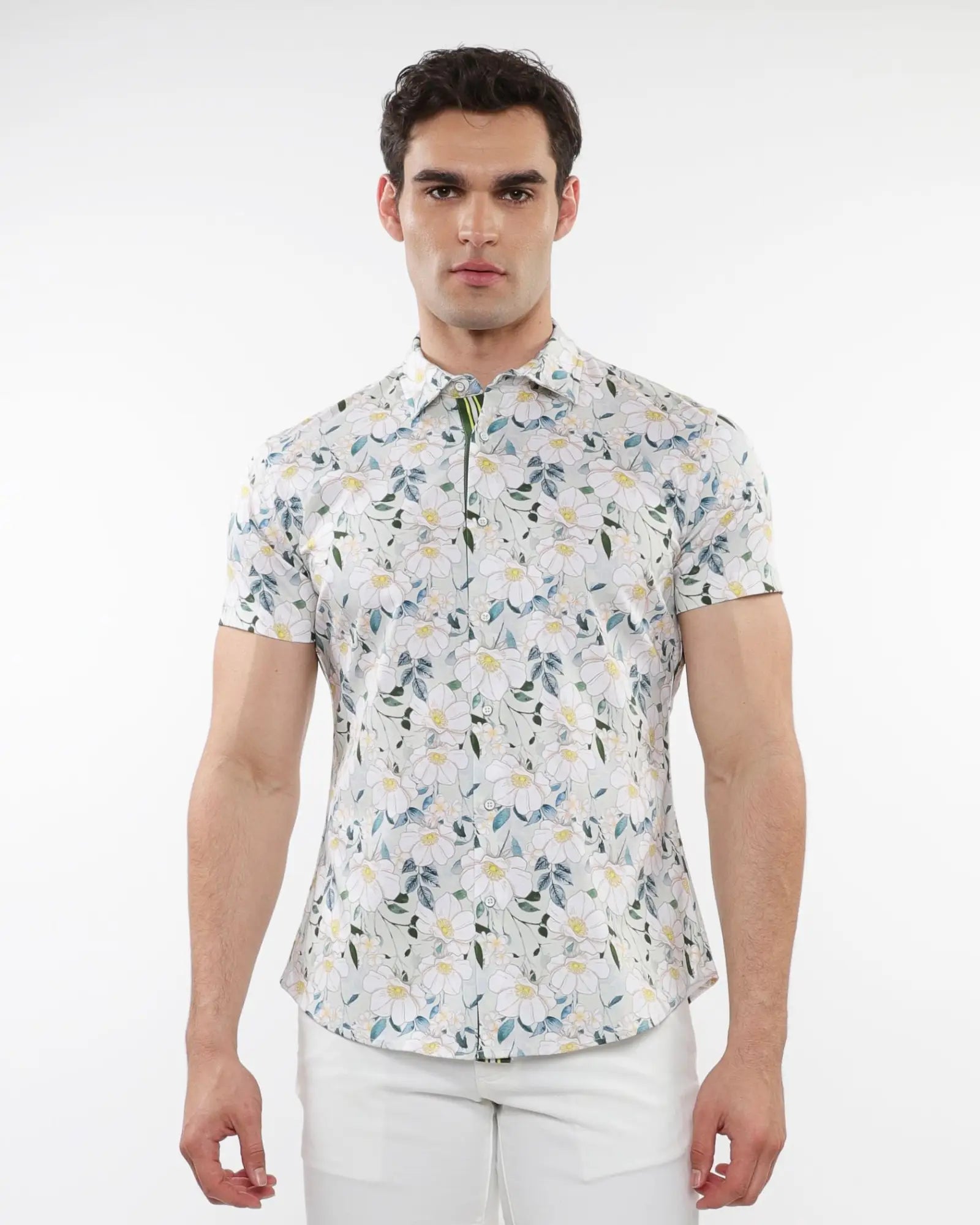 A man wearing a white floral print stretch knit short-sleeved shirt with green and yellow patterns