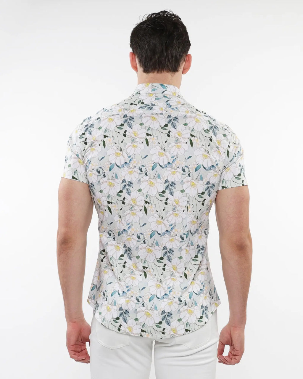 A man wearing a white floral print stretch knit short-sleeved shirt with green blue and yellow patterns