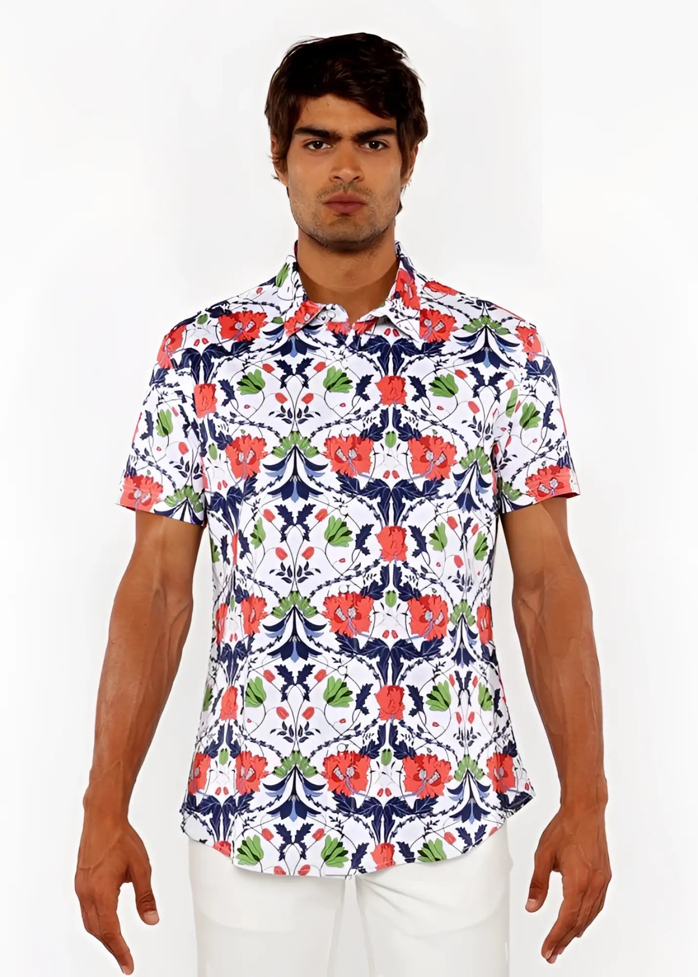 A man wearing a floral print stretch knit short sleeve shirt with red poppies green leaves and navy vines on white