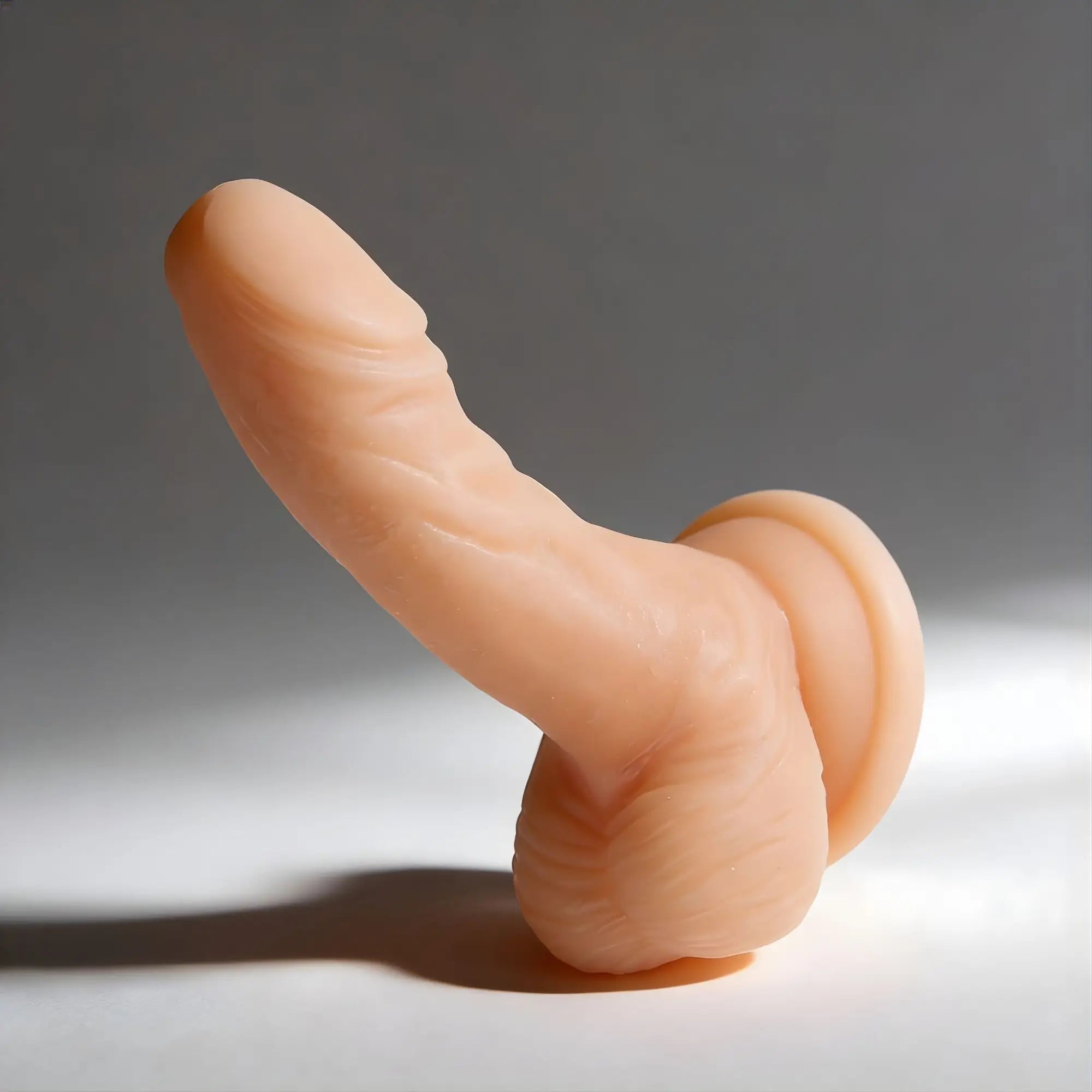 Frisky 4-Inch Silicone Beginner Cock, a realistic, flesh-toned textured dildo with a flat suction cup base.