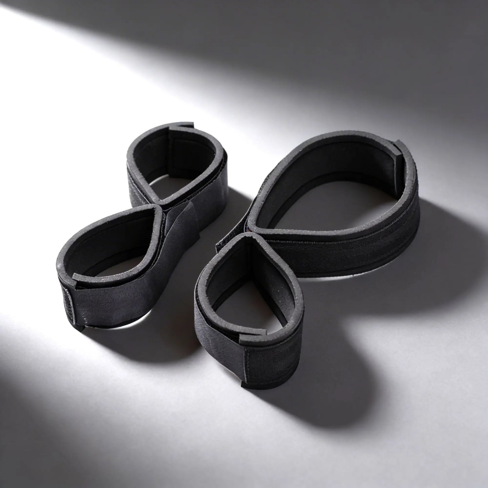 Frisky Double Leg and Arm Restraints: Two black, adjustable foam-padded figure-eight loops on a gray background.
