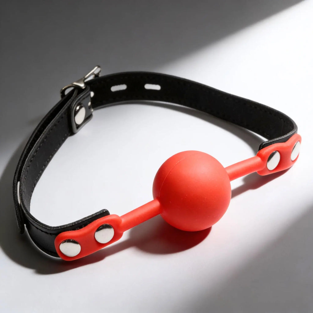 Frisky Silicone Comfort Ball Gag with a vibrant red sphere and an adjustable black leather-style collar.