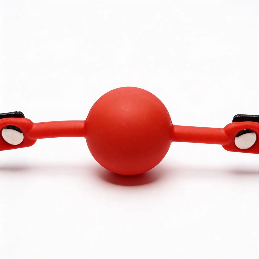 Frisky The Silicone Comfort Ball Gag in bright red, featuring a round ball with integrated straps and silver metal studs.