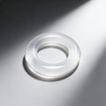 Frisky Super Stretch Universal Cock Ring: A smooth, transparent, circular silicone ring on a gray background.