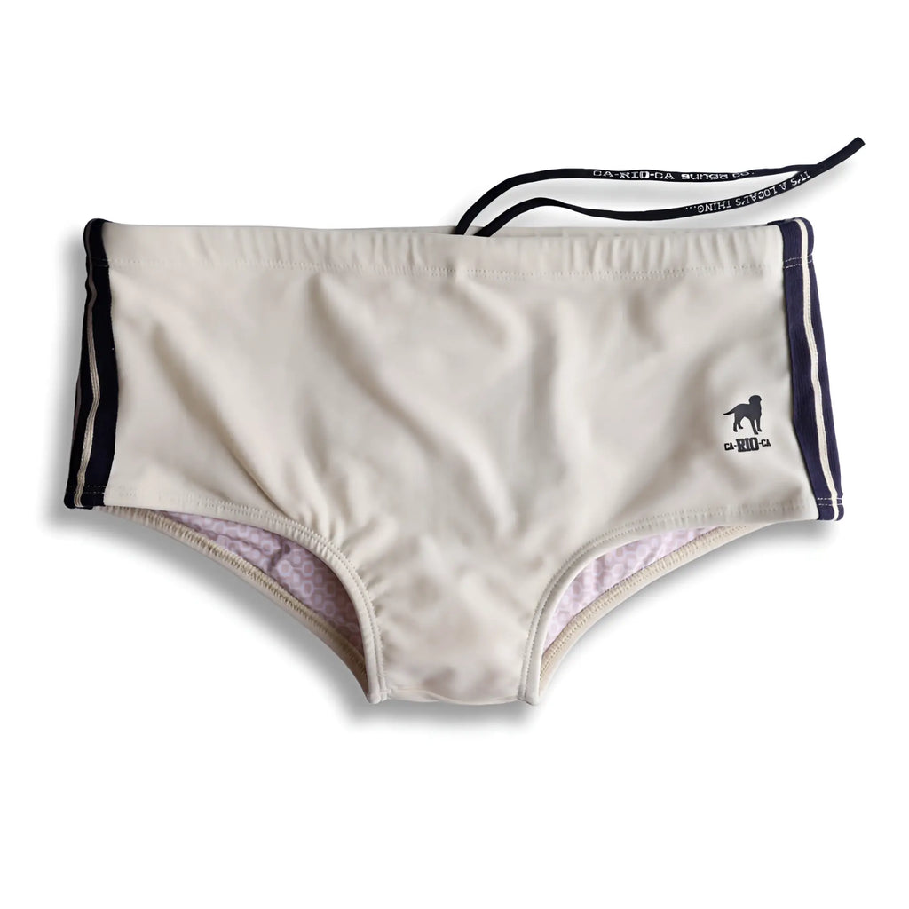 Beige galão creme sunga designer swim shorts with navy blue side stripes and a small black dog logo on the leg
