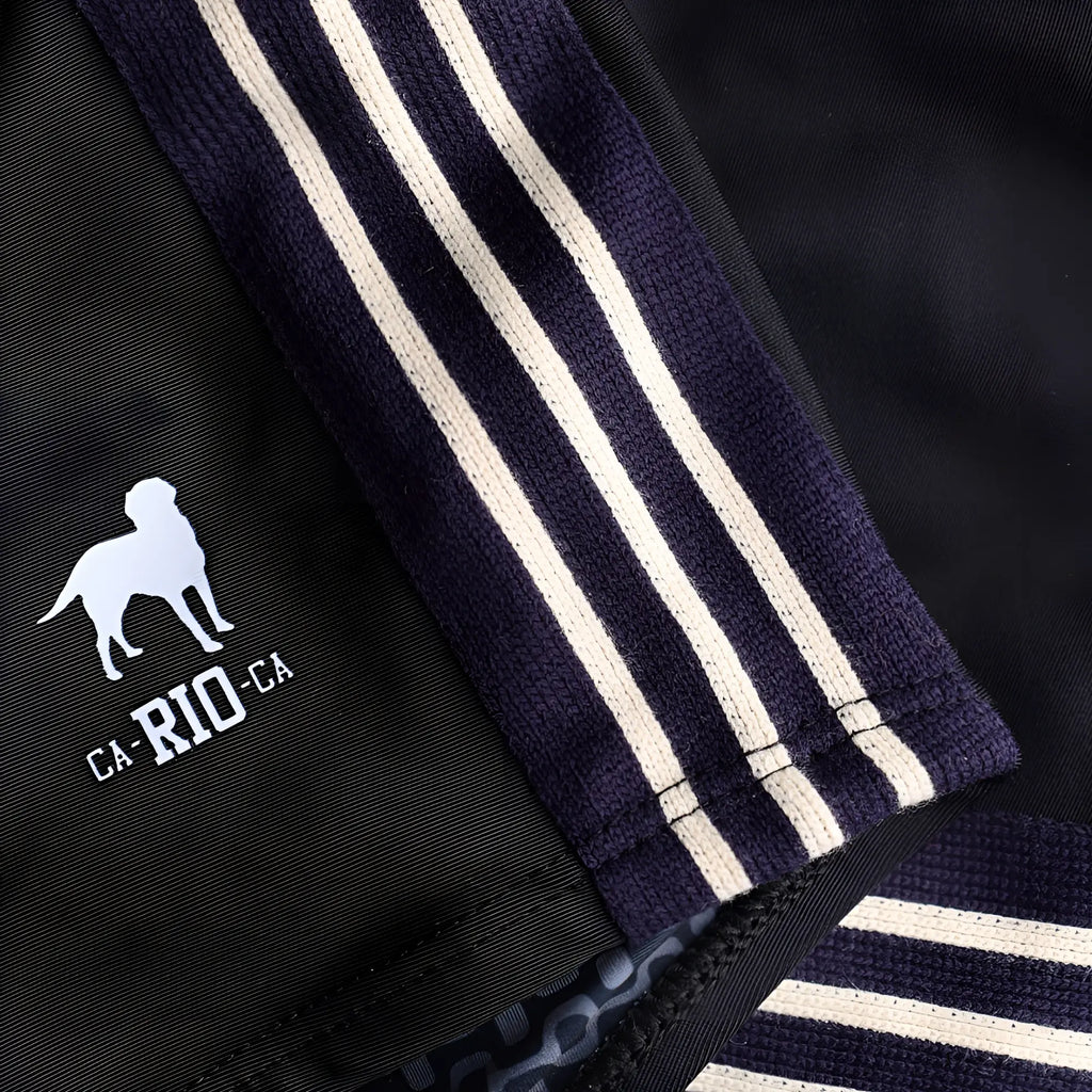 Black athletic jacket with navy blue ribbed cuffs featuring three white stripes and a white dog logo near the hem