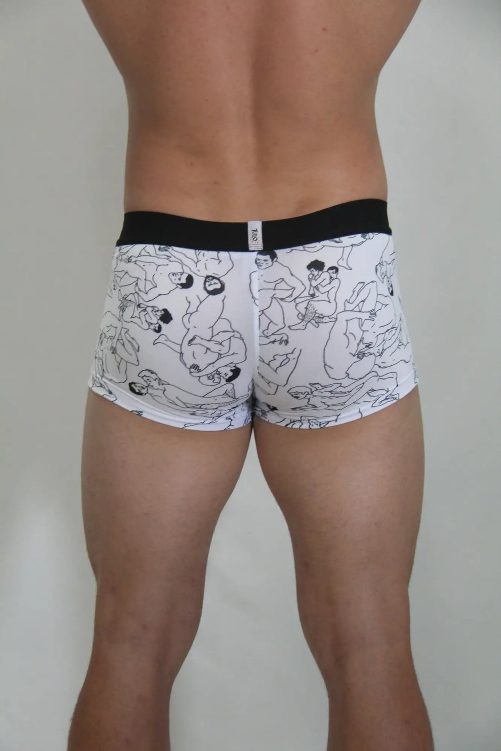 White boxer briefs with black line drawing figures and a solid black waistband from the gay karmasutra trunk collection