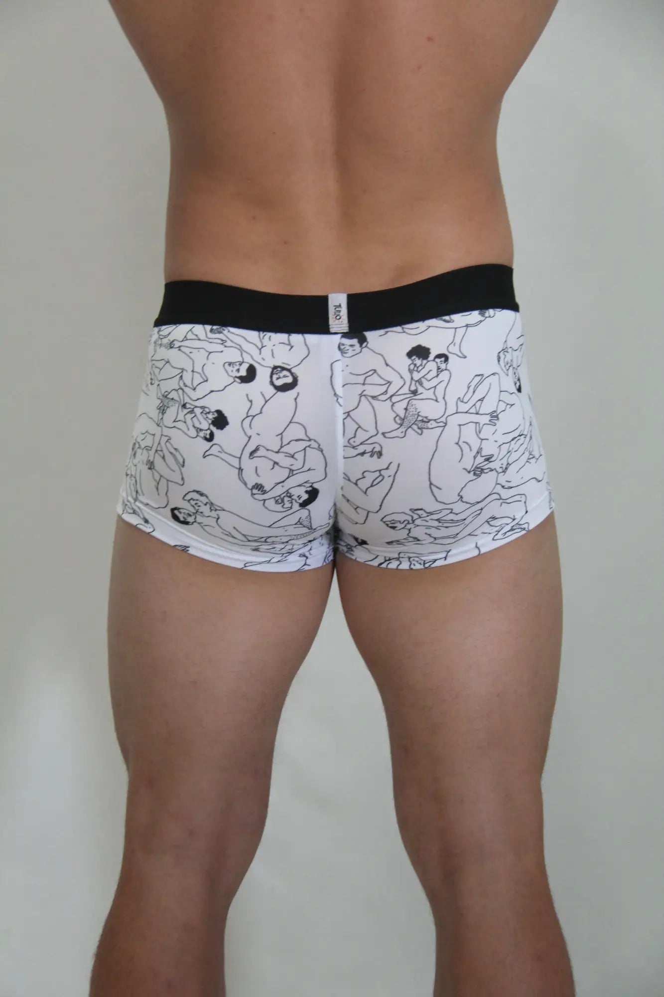 White boxer briefs with black line drawing figures and a solid black waistband from the gay karmasutra trunk collection