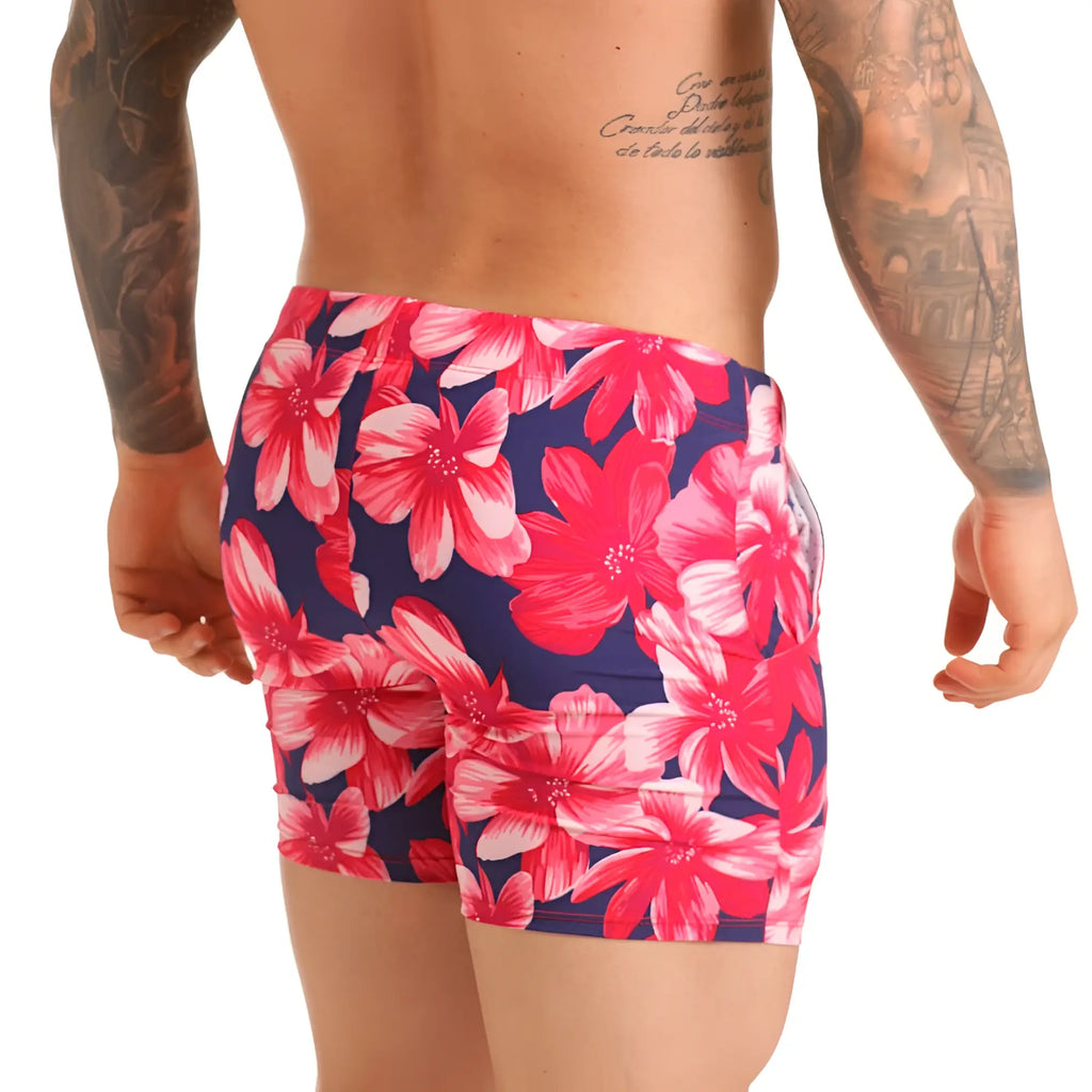 Vibrant pink and white floral patterned swim trunks on navy blue base for gigo flowers fuchsia beachwear