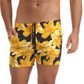 Black swim trunks with vibrant yellow and white floral pattern and drawstring waistband from Gigo Flowers Yellow Beachwear