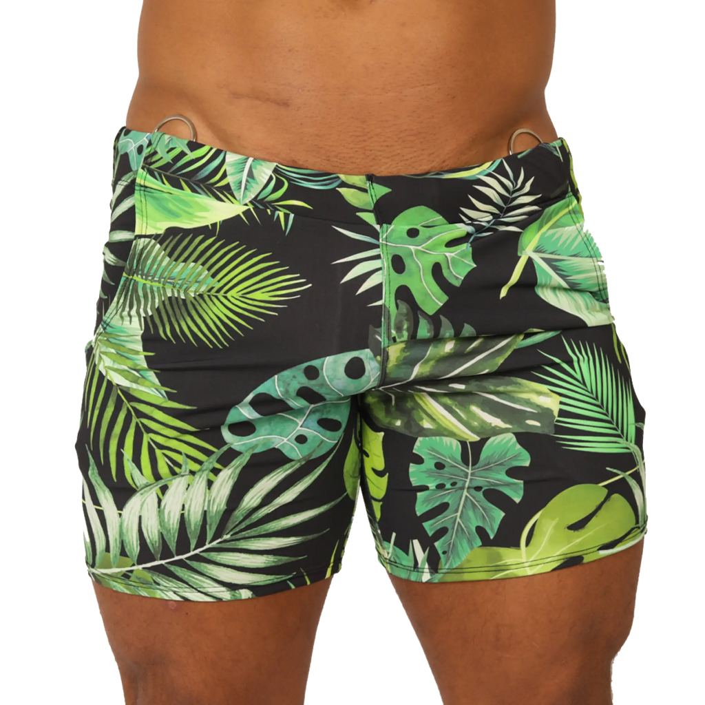 Black swim trunks with vibrant green and lime tropical leaf pattern and metallic silver waistband rings by Gigo Forest Beachwear