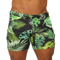 Black swim trunks with vibrant green and lime tropical leaf pattern and metallic silver waistband rings by Gigo Forest Beachwear
