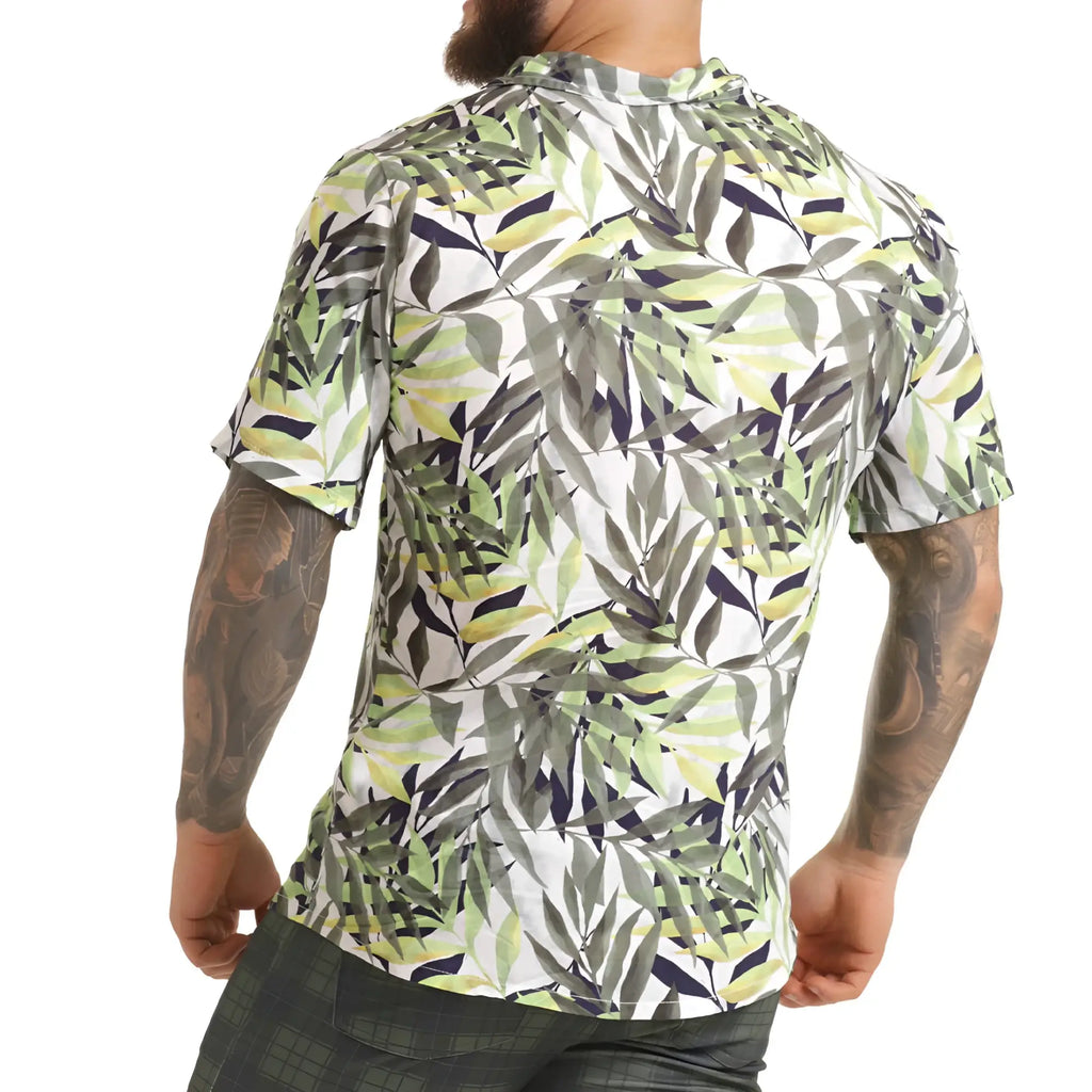 A men’s short-sleeved button-up gigo jungle shirt with vibrant green gray and navy tropical leaf pattern on white background