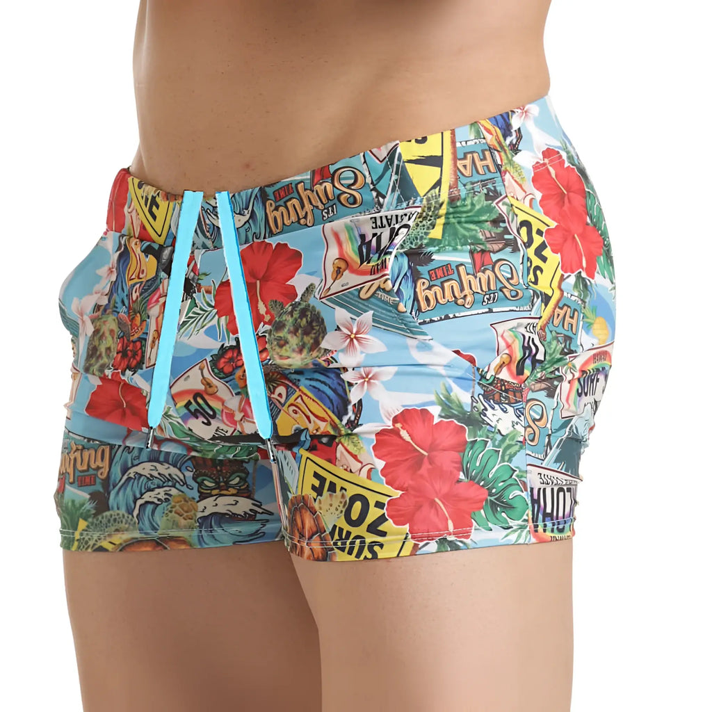Gigo Seventies beachwear brightly colored swim trunks with tropical collage print on light blue fabric