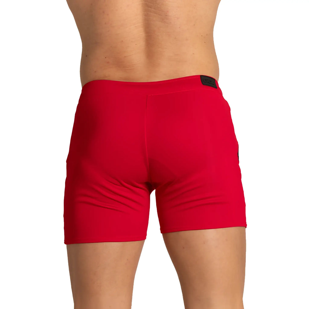 Red athletic training shorts with black brand tag at waistband designed for performance and comfort