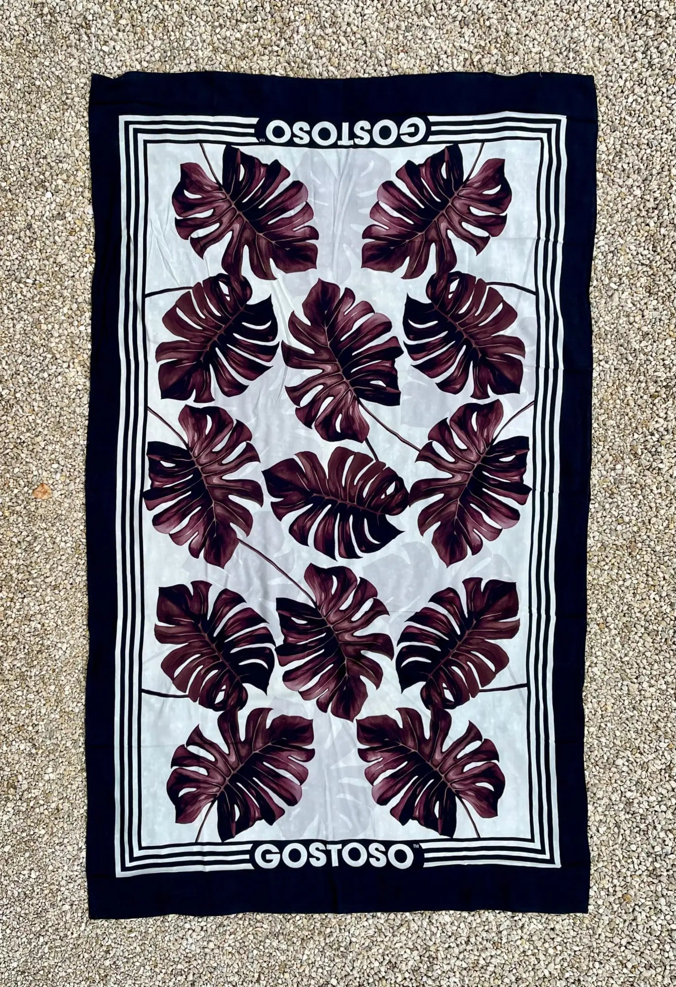 Navy blue and white gostoso canga de praia beach towel with bold maroon monstera leaf pattern for Brazilian beachwear