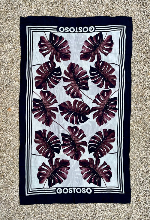 Navy blue and white gostoso canga de praia beach towel with bold maroon monstera leaf pattern for Brazilian beachwear