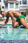 Green swim brief made of bright green fabric with a subtle logo on the side for swimming and beachwear