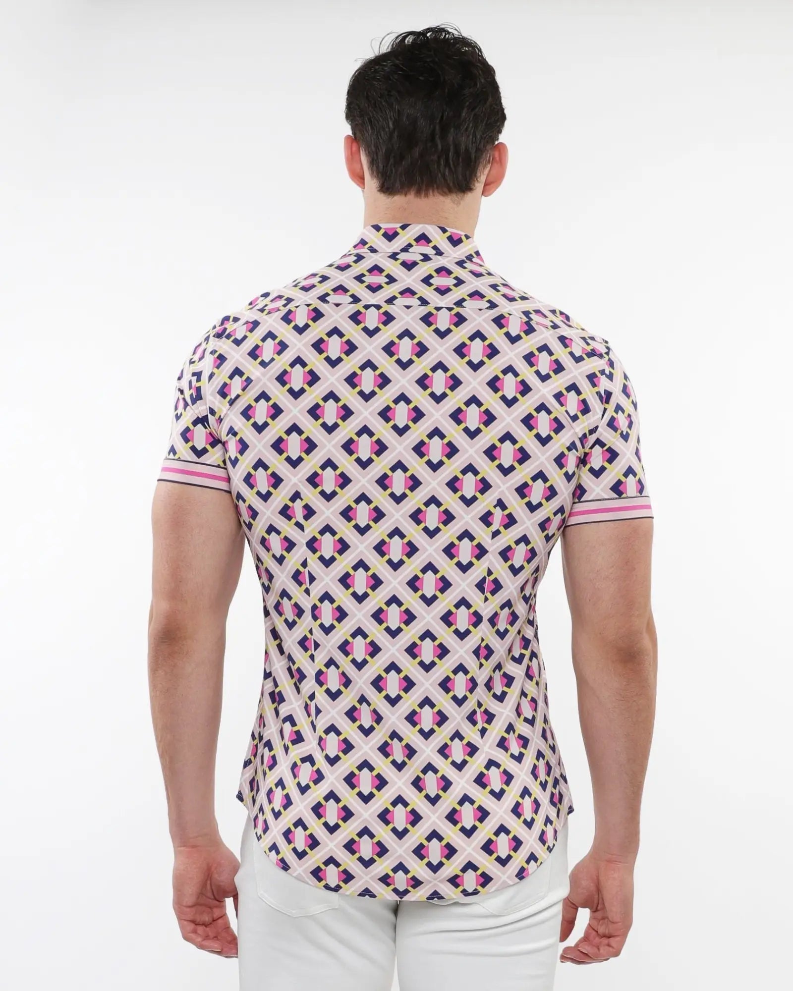 A man wearing a grid parquet printed performance short-sleeved shirt with pink purple and cream geometric pattern