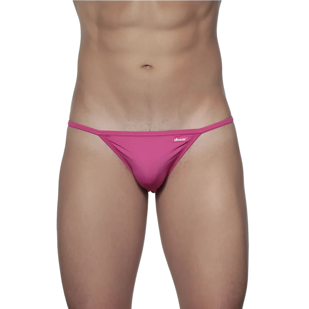 A vibrant pink form-fitting thong made of smooth fabric with a small brand tag on the waistband groovin string bikini