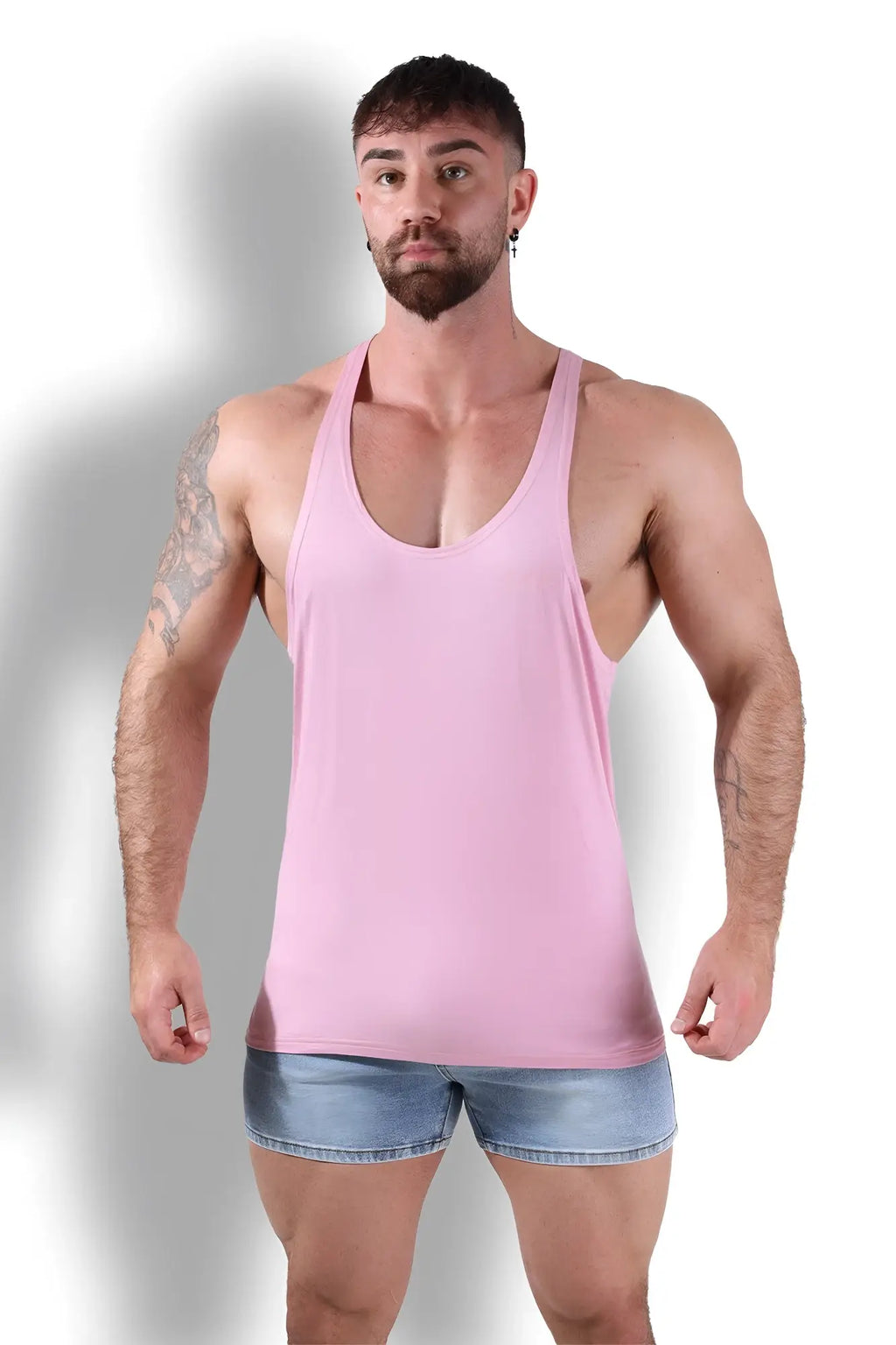 A sleek light pink gym bae classic workout stringer racerback tank top with smooth fabric finish