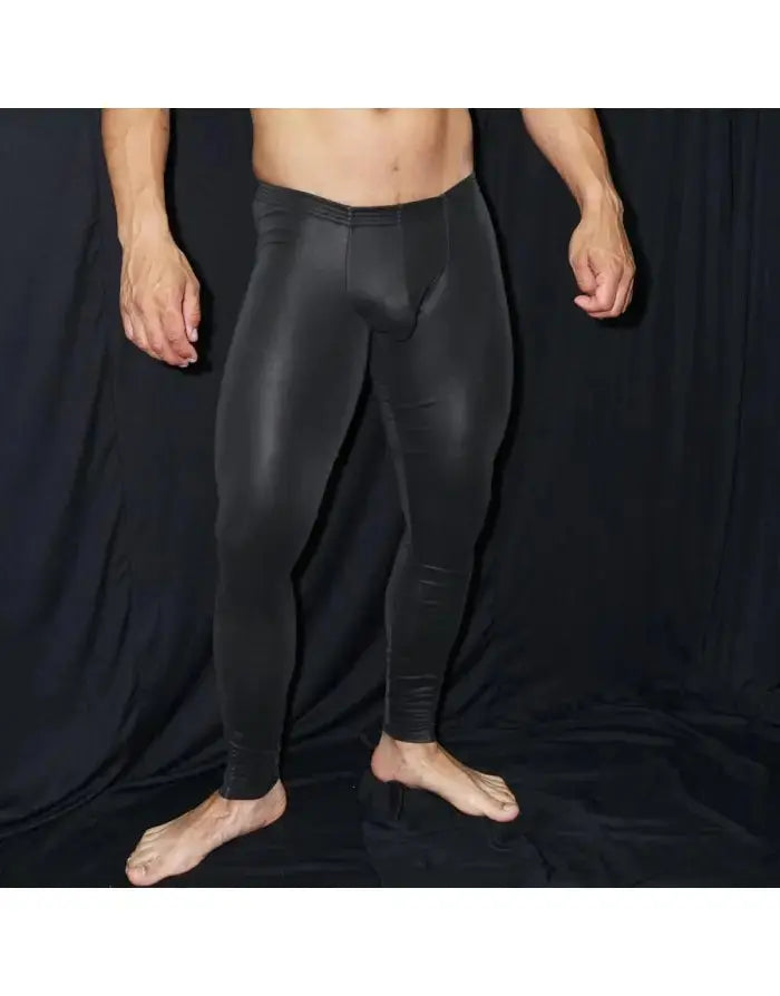 Black eco leather runner tights by Arroyman featuring a sleek fit and smooth texture shown on a model standing barefoot.