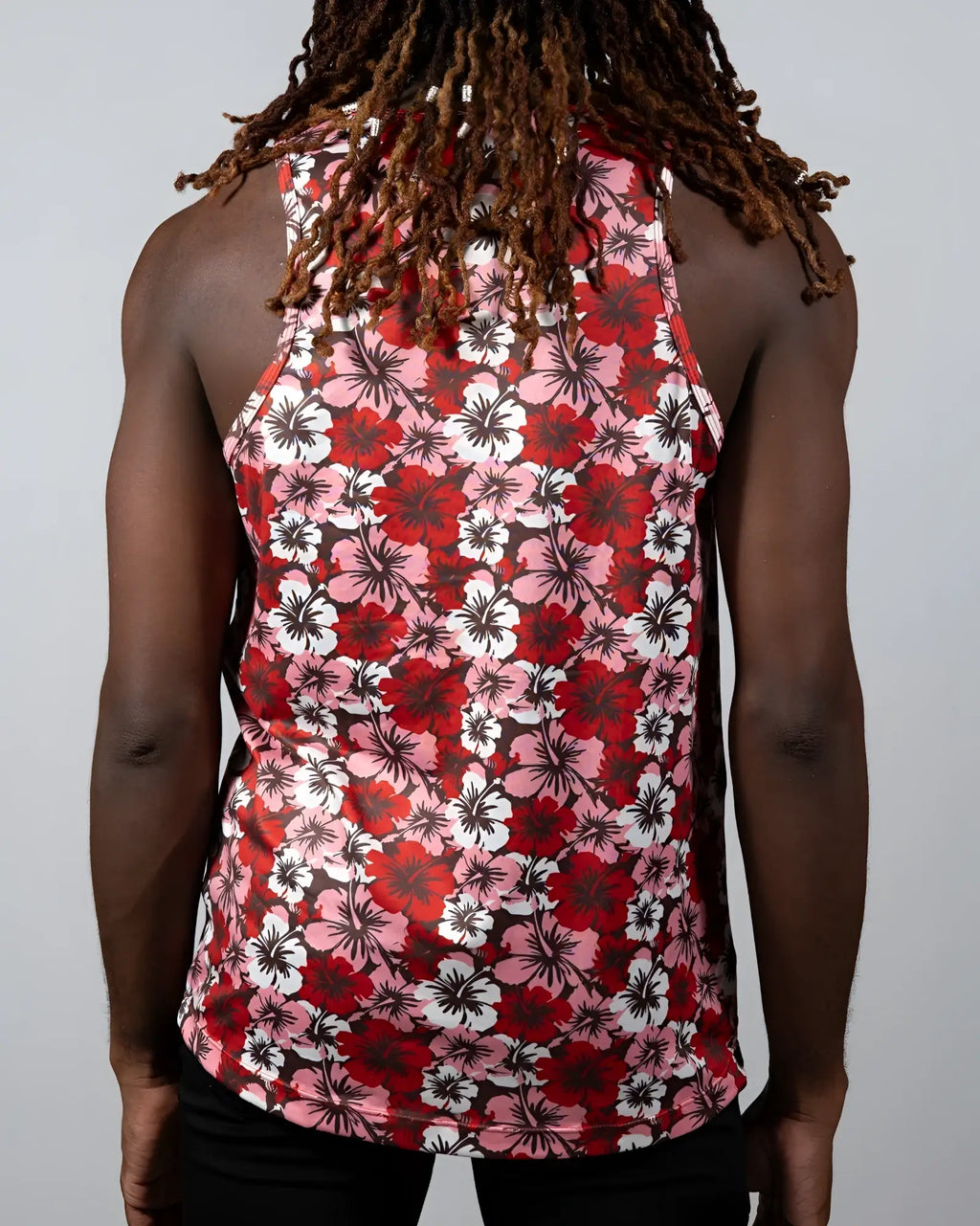 A vibrant red pink and white floral-patterned hawaiian hibiscus print tank top with a black background