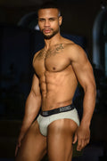 Heather grey bottomless brief made of light gray fabric with a black adonis waistband and white logo lettering