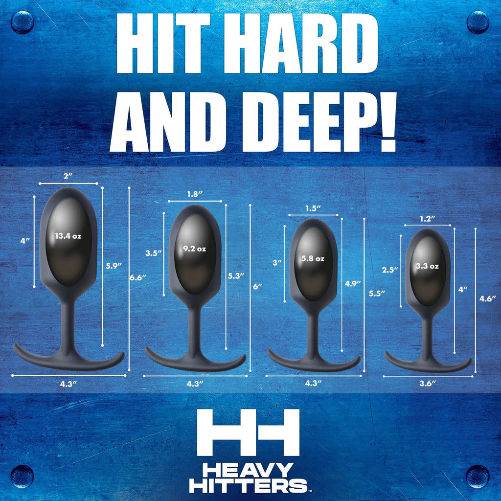 Four black Heavy Hitters silicone bullet plugs of varying sizes with dimension labels against a blue metal background.