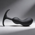 Heavy Hitters matte black silicone prostate plug with a curved, weighted shaft and a flared, ergonomic T-shaped base.