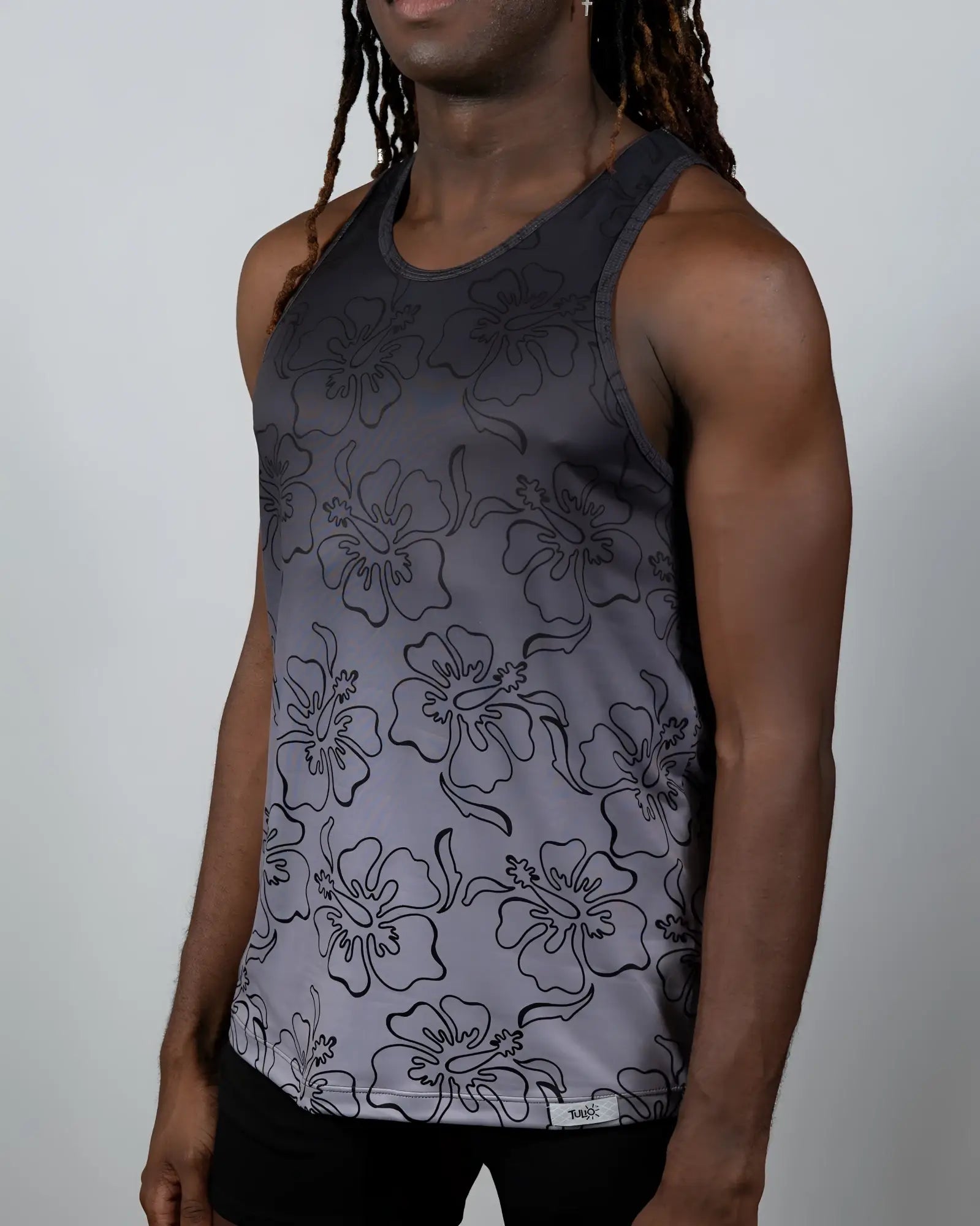 A dark gray hibiscus ombre print tank top with black outlined flowers and subtle fading to lighter gray at the bottom