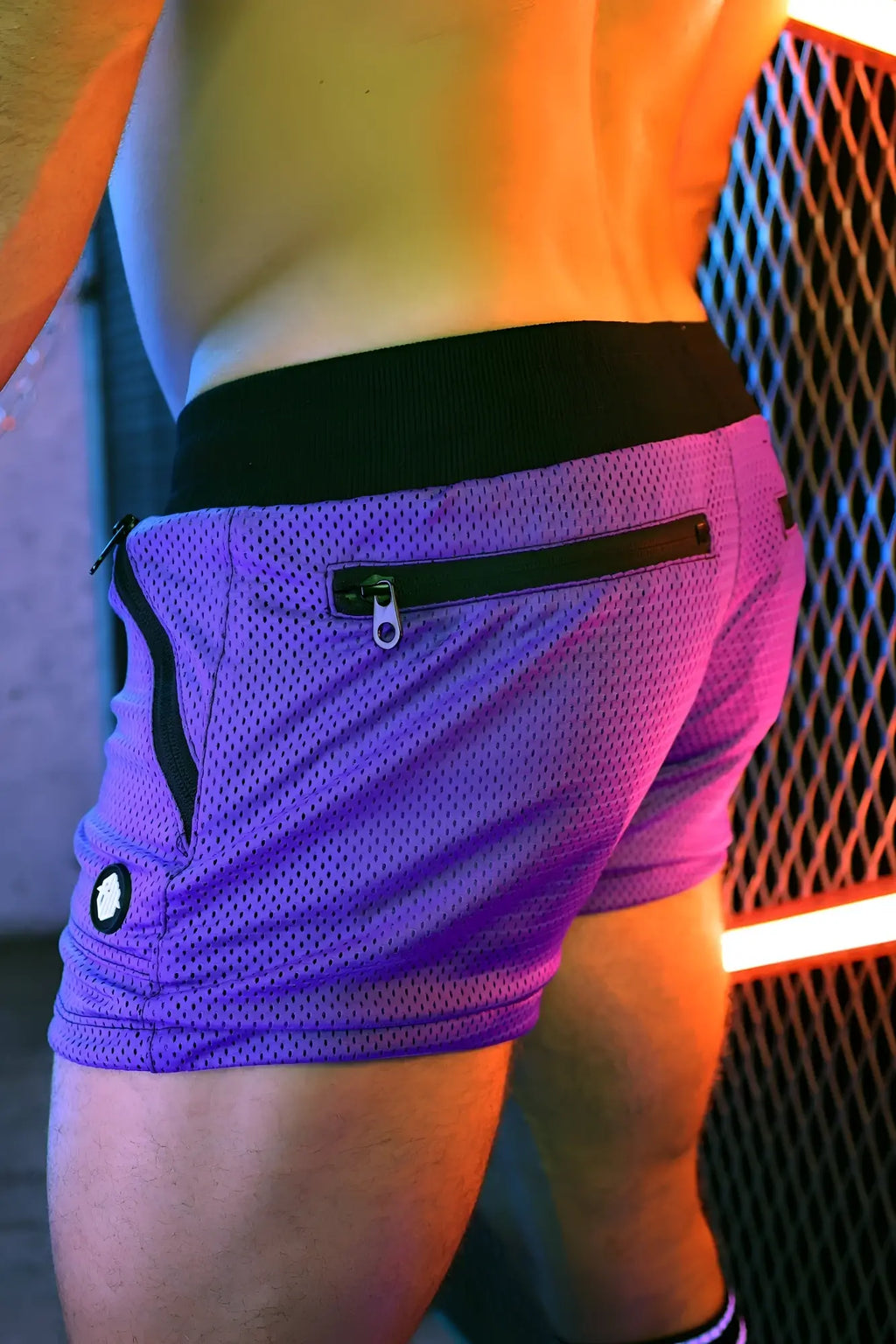 Purple hook up shorts made of mesh fabric with black waistband and zipper details for athletic use