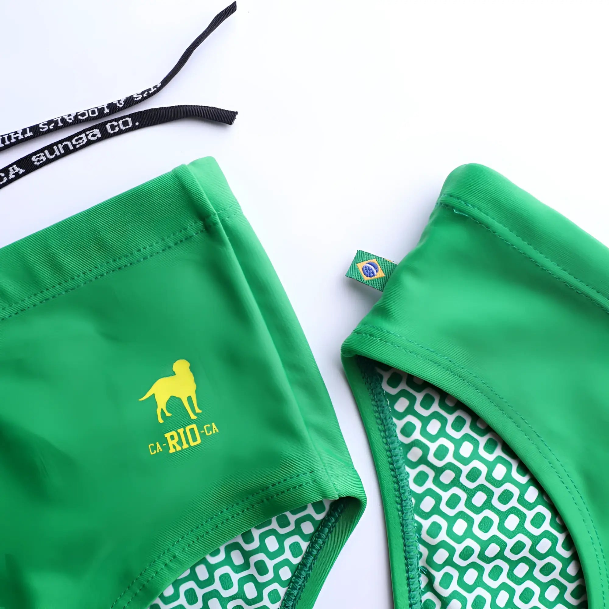 Hortelã green solid men’s swimming sunga featuring a green bikini bottom with yellow dog logo and white geometric lining