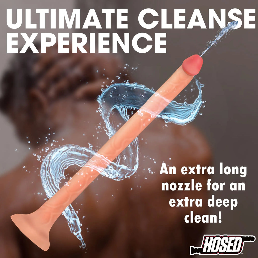 Hosed 12" slim silicone enema hose in peach, shown spraying water with a splash effect against a blurred background.