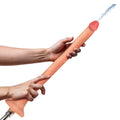 Hosed 12" Slim Silicone Enema Hose: A tan, phallic-shaped silicone hose held by hands, spraying water from the tip.
