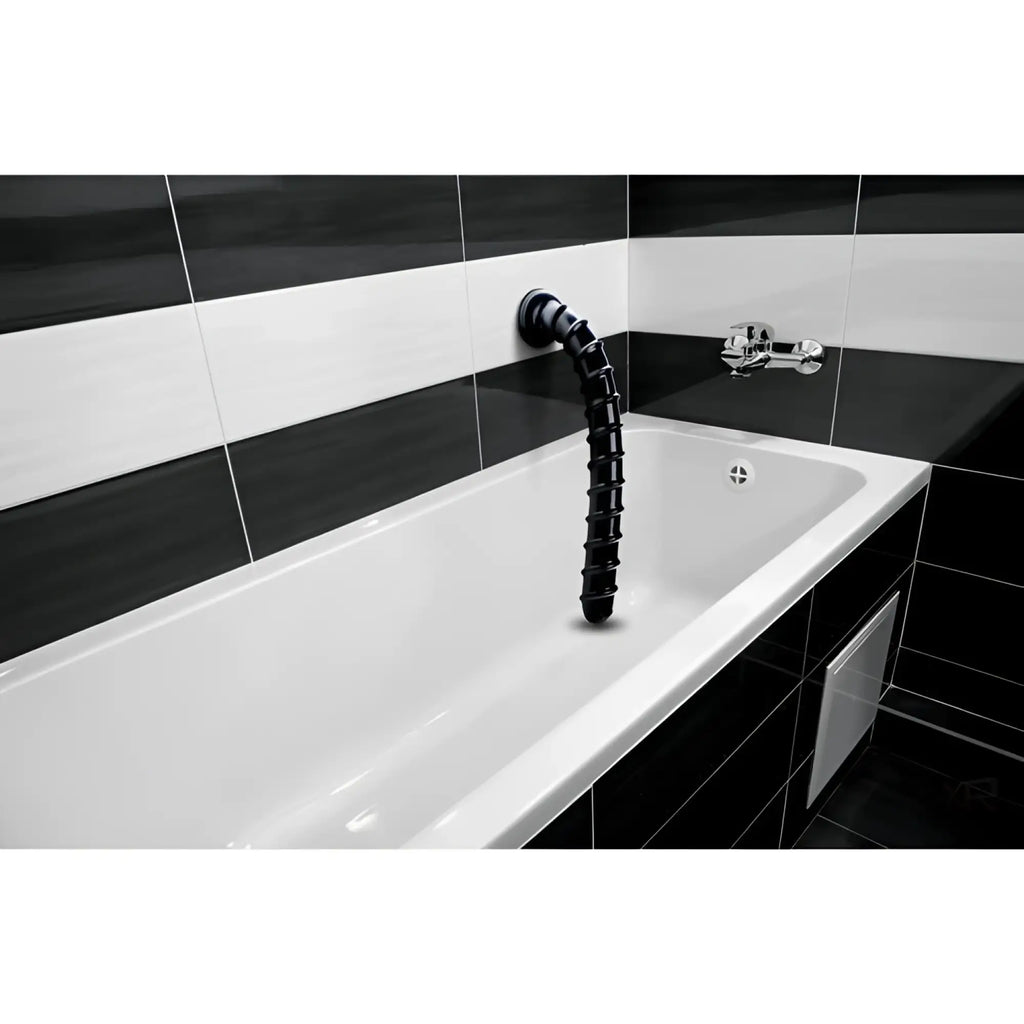 Hosed 18-inch black swirl thick anal snake mounted on a bathroom wall above a white tub with black and white tile.