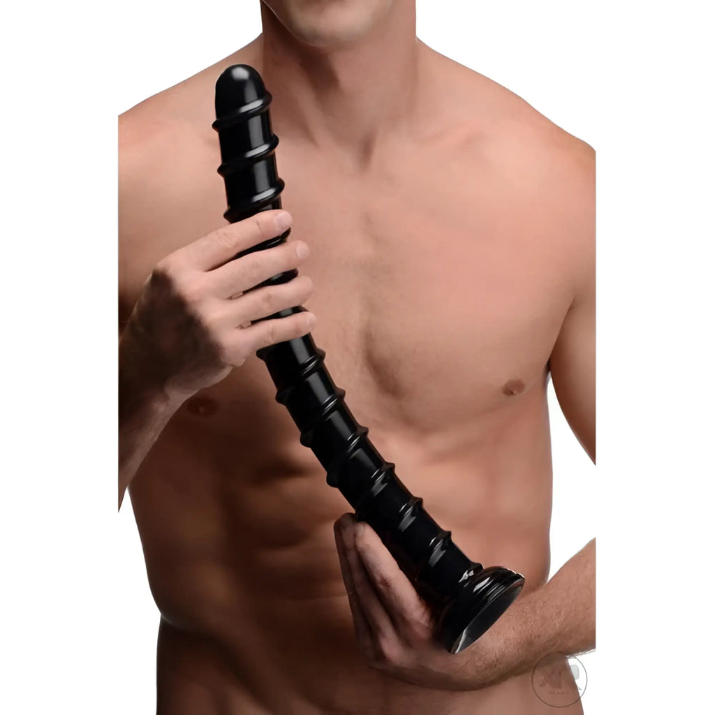 A person holding a black, 18-inch Hosed Hosed swirl-textured anal snake toy with a flared suction cup base.