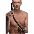 A man holding a long, thin black 18-inch Hosed Swirl anal snake toy with a spiral texture and flared base.