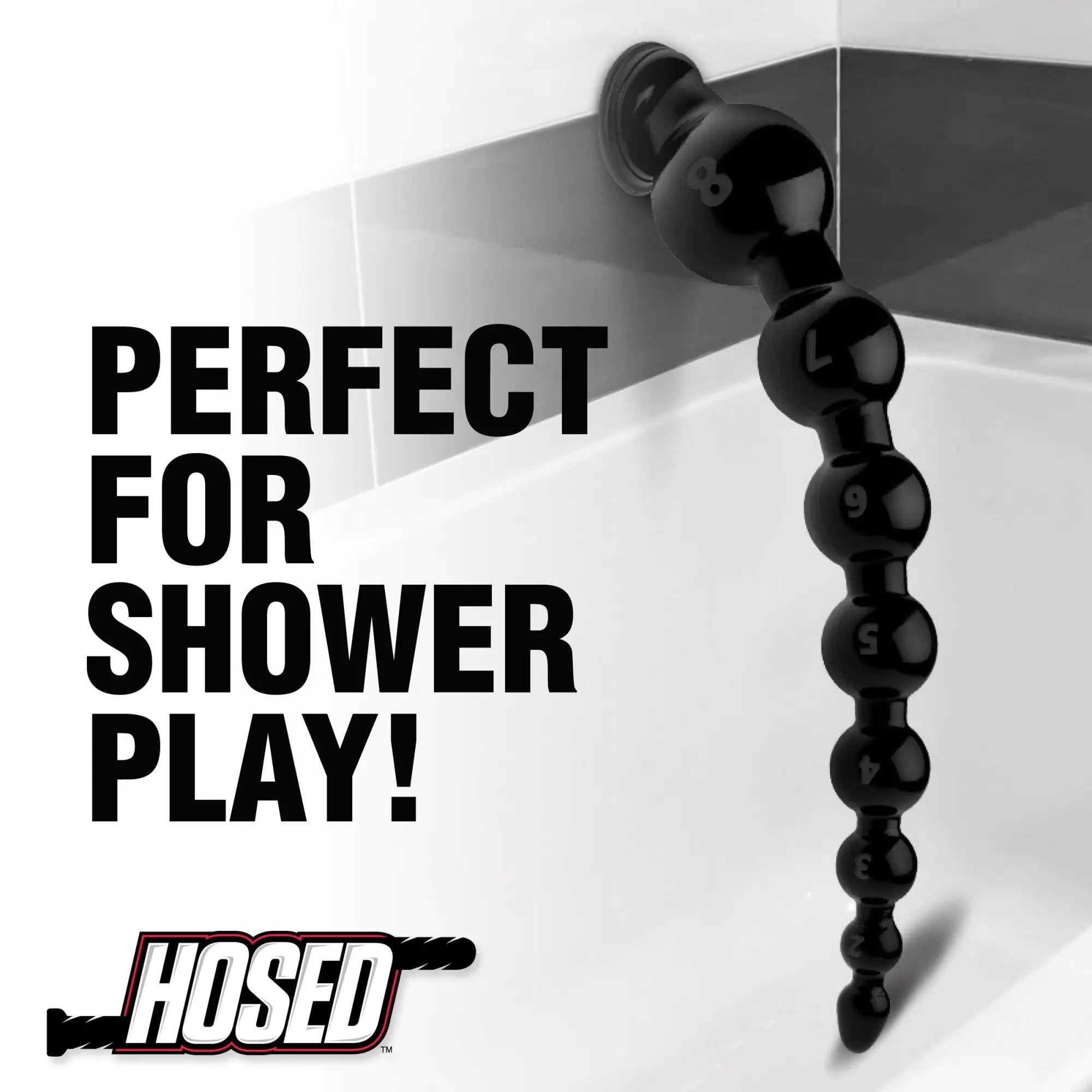 Hosed 19" black graduated beaded anal snake with suction cup base attached to a shower wall.