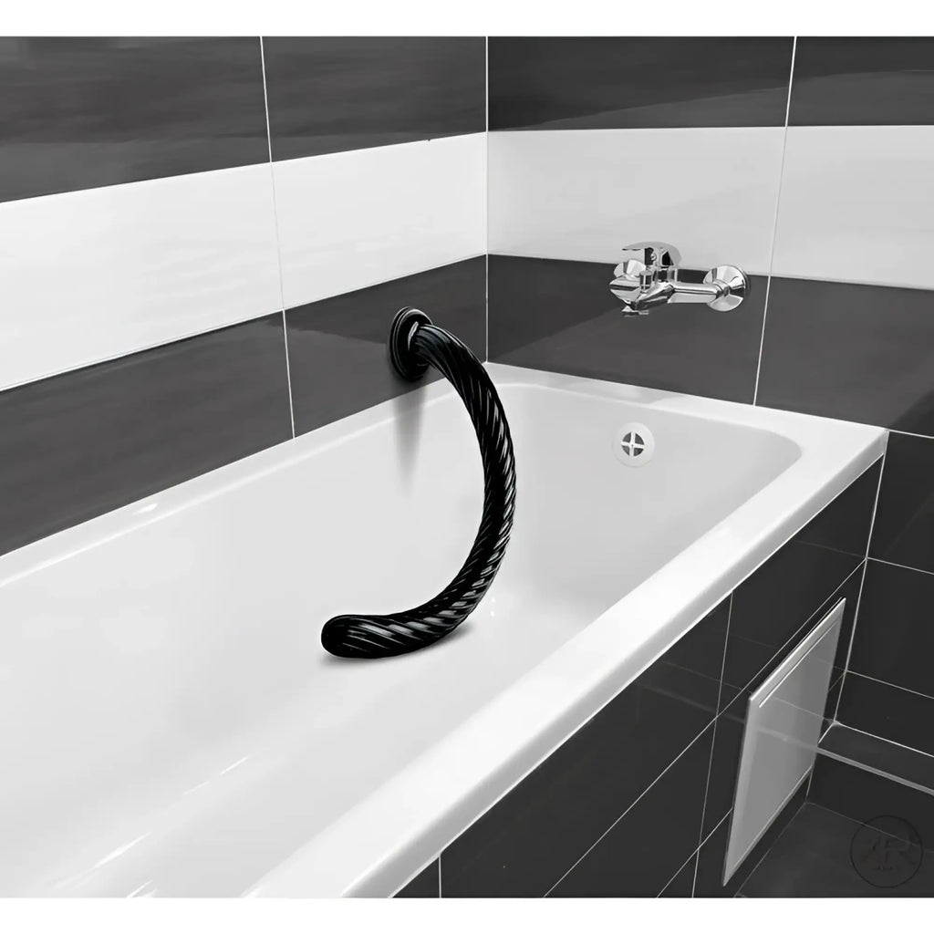 Hosed 19-inch black, spiraled-texture anal snake suctioned to the side of a white bathtub in a tiled bathroom.