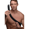 A shirtless man holds a long, black, 19-inch Hosed anal snake with a flexible, spiraled ribbed texture.